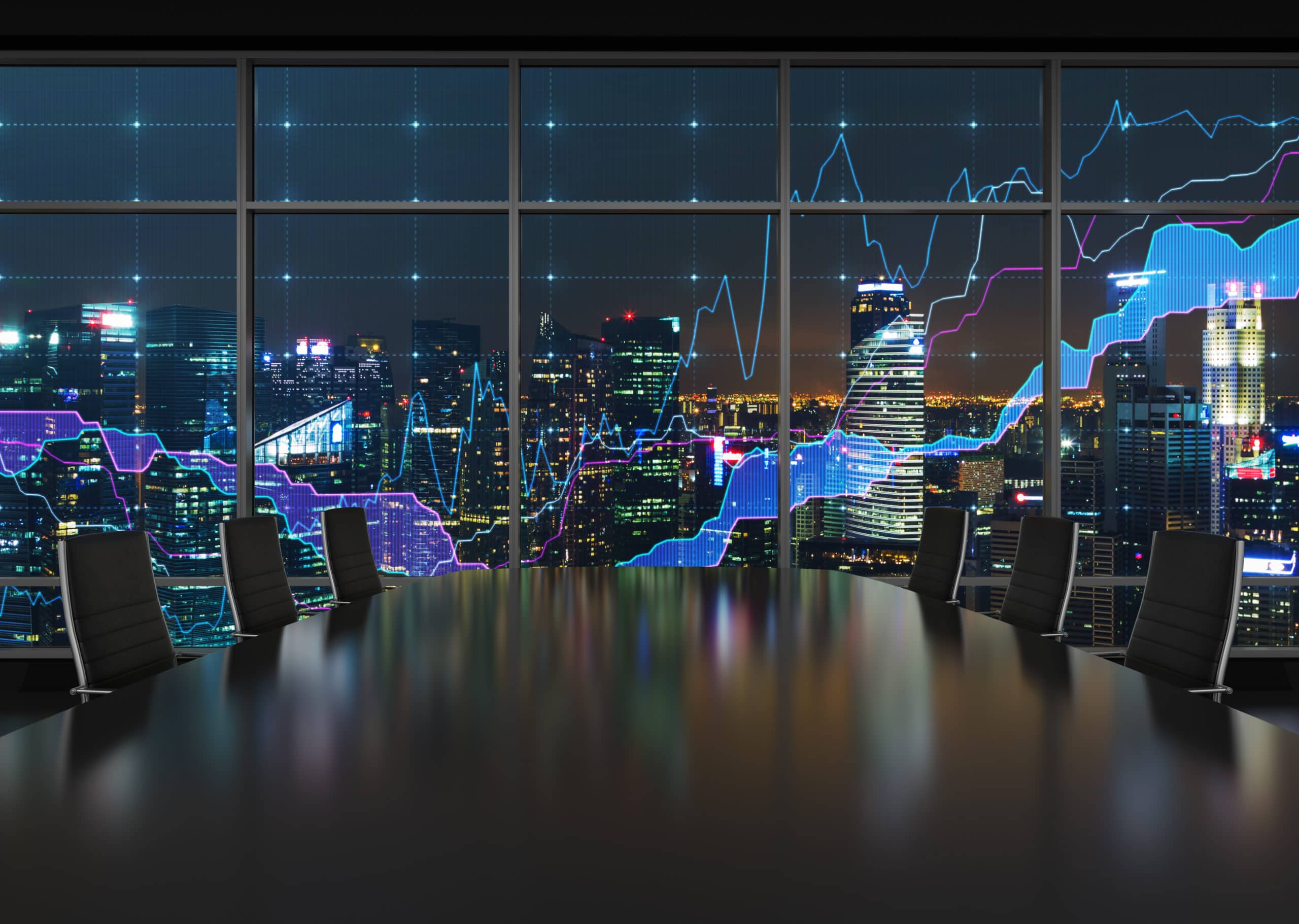 High-rise city skyline at night with illuminated stock market graphics on glass windows.