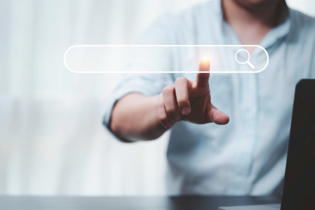 A business owner touches a floating search bar, symbolizing SEO services for small businesses in North Carolina.